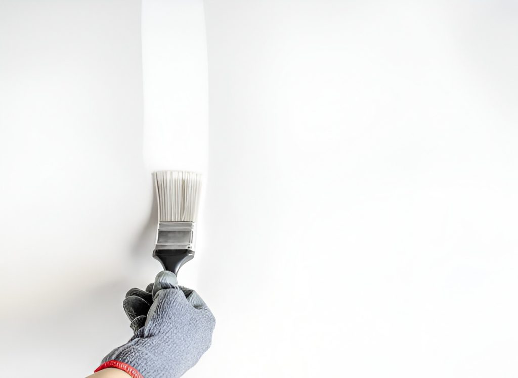 close-up of a person painting a wall with a paintbrush