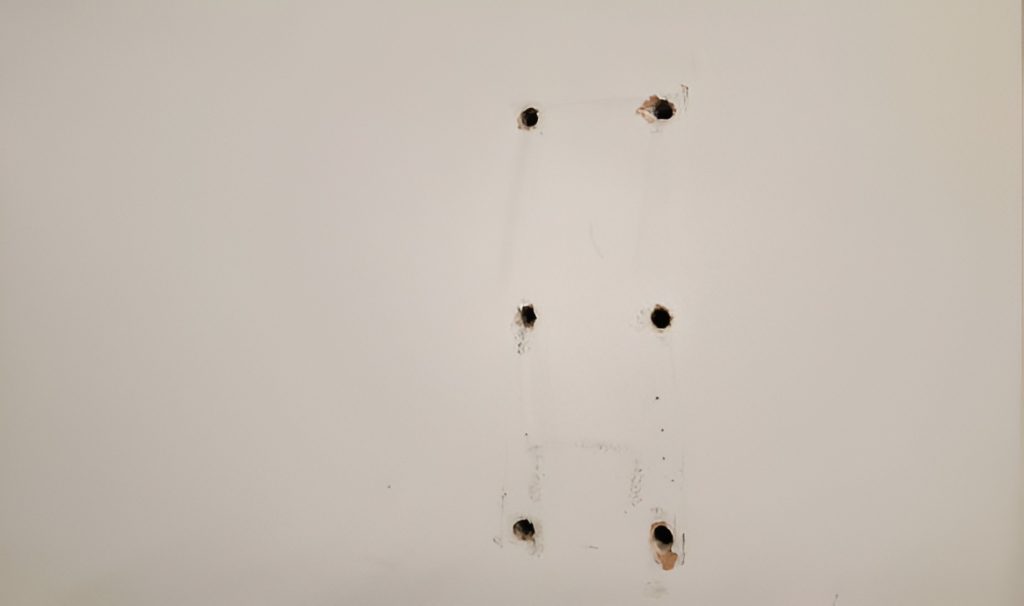 six drywall anchor holes